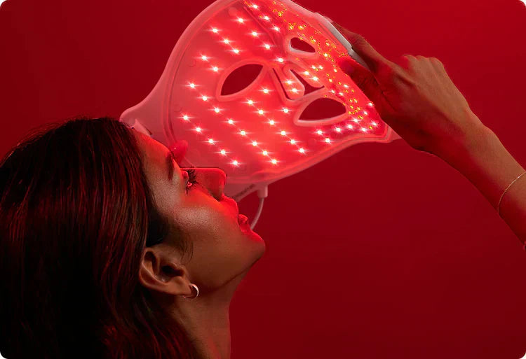 une femme en train de mettre un masque led visage lumiere rouge avec les led allumé